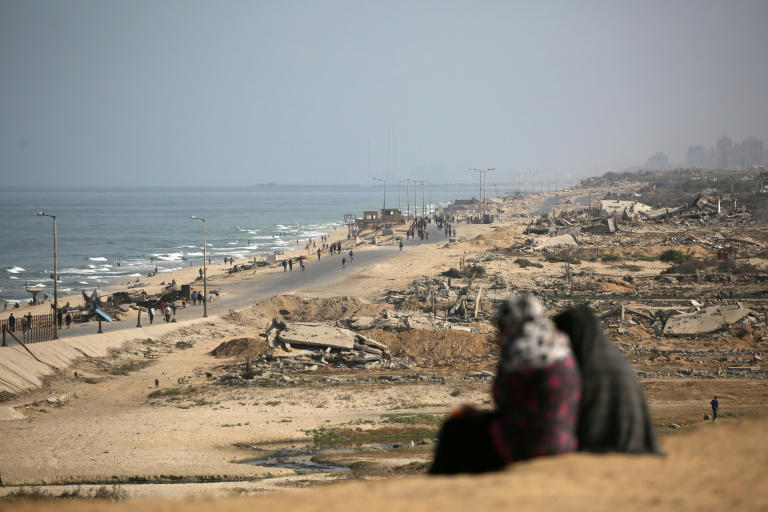 Palestinos circulam pela via costeira do acampamentos de deslocados de Nuseirat, na Faixa de Gaza, em 4 de outubro de 2025