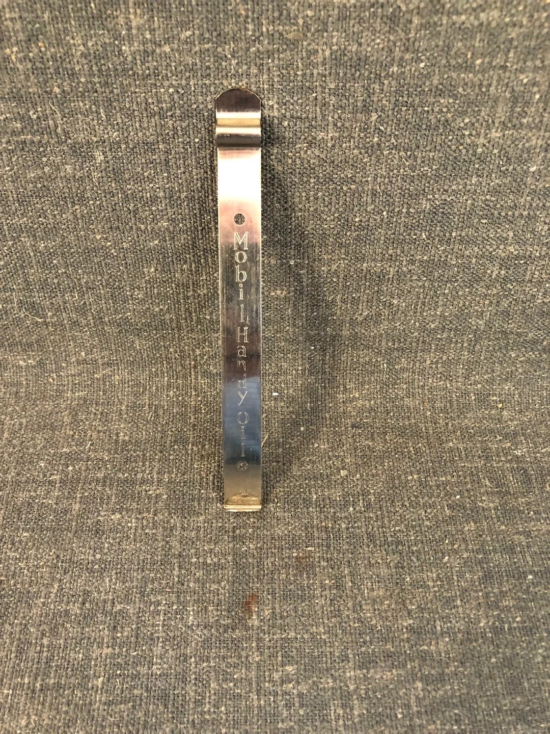 Metal scraper with the engraved text: “Mobil Handy Oil.”