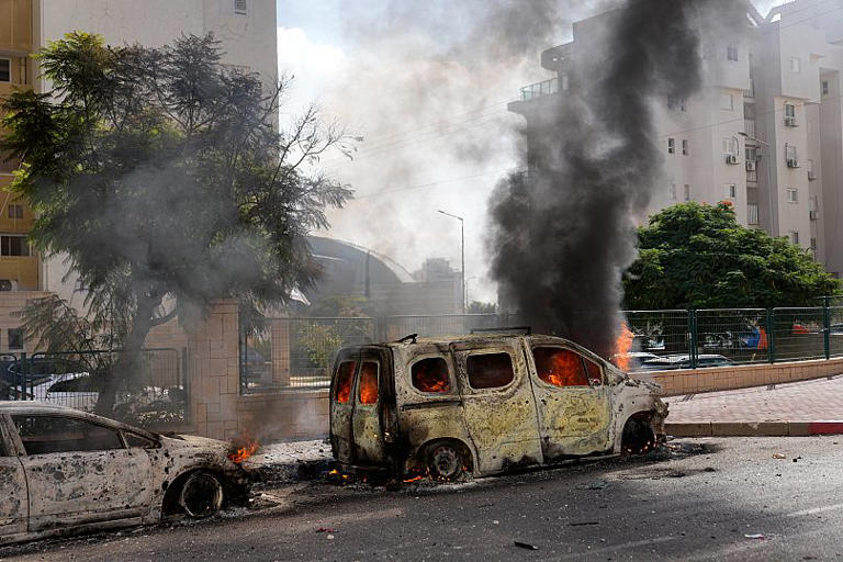 Cars are on fire after they were hit by rockets from the Gaza Strip in Ashkelon, 7 October, 2023 AP Photo