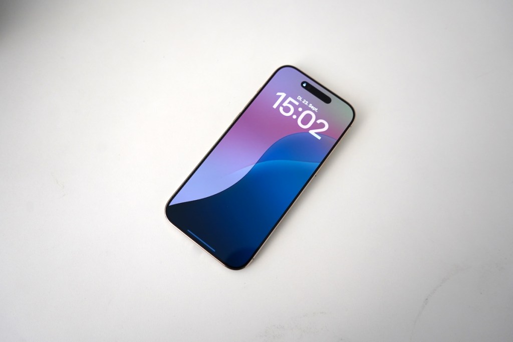 Ein Smartphone liegt auf einem weißen Tisch.