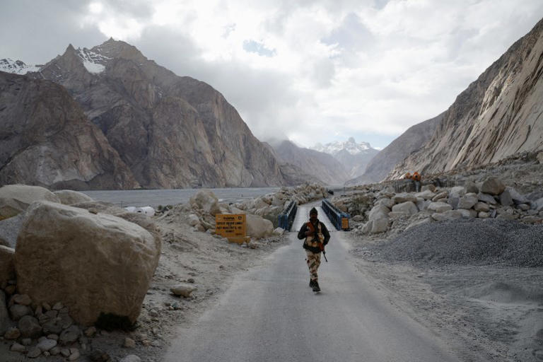 An Indian security personnel stands guard near the Siachen base camp road, in Ladakh’s remote Warshi village [Sharafat Ali/Reuters]
