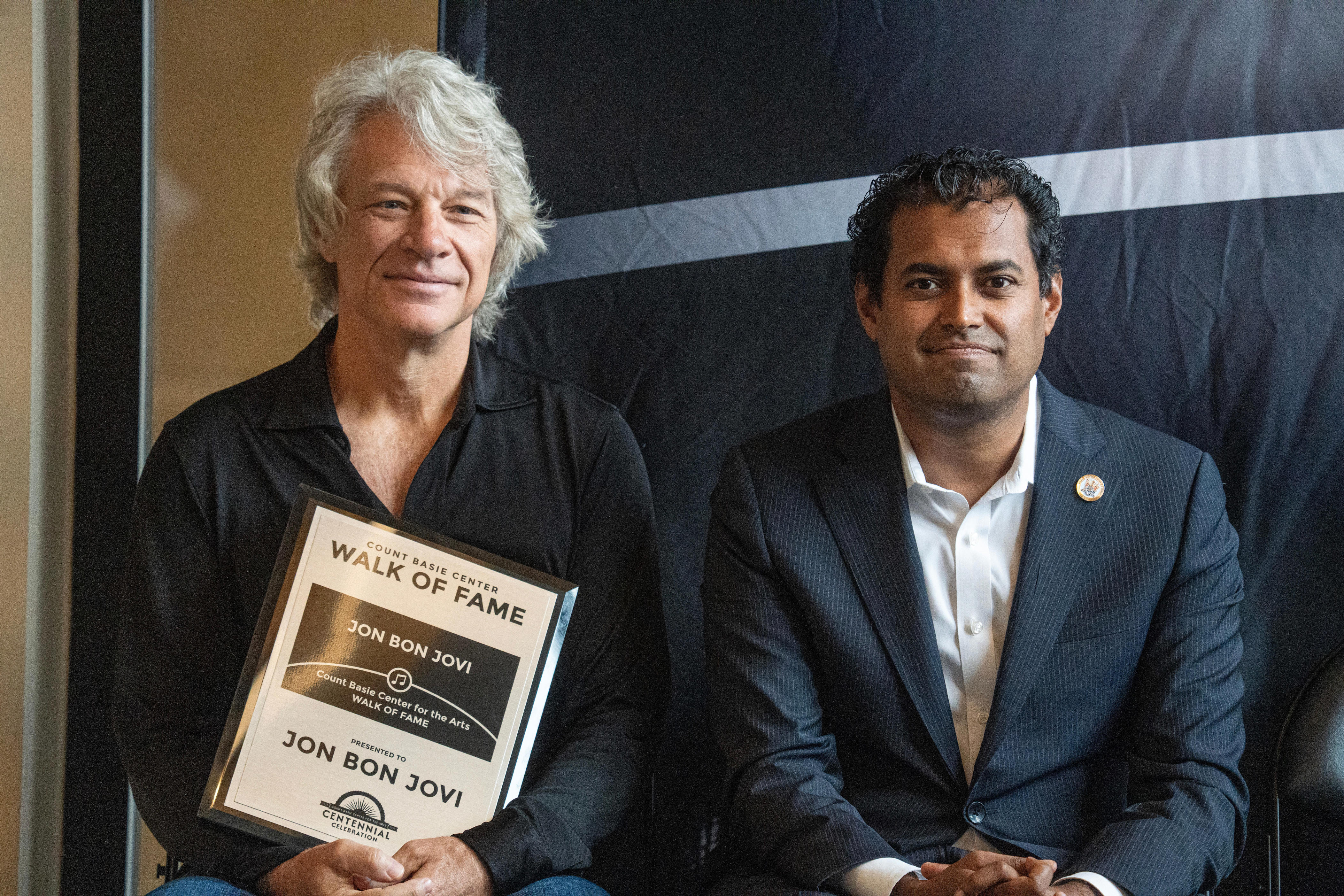 Senator Vin Gopal sits beside Jon Bon Jovi after introducing him to speak during JBJ's Walk of Fame ceremony at the Count Basie Center for the Arts, in Red Bank. September 25, 2025