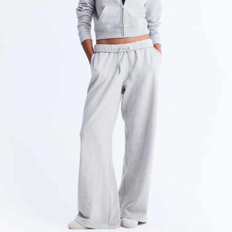 A woman wearing grey wide-leg tracksuit bottoms