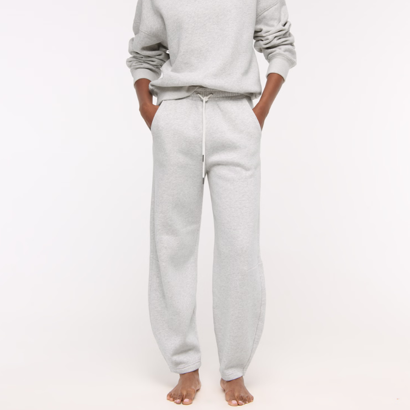 A woman wears grey barrel leg tracksuit bottoms