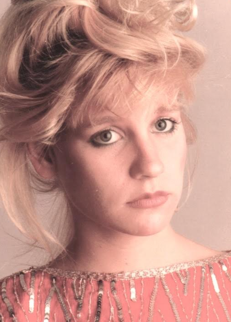 Person with tousled hair gazes forward, wearing a sequined top