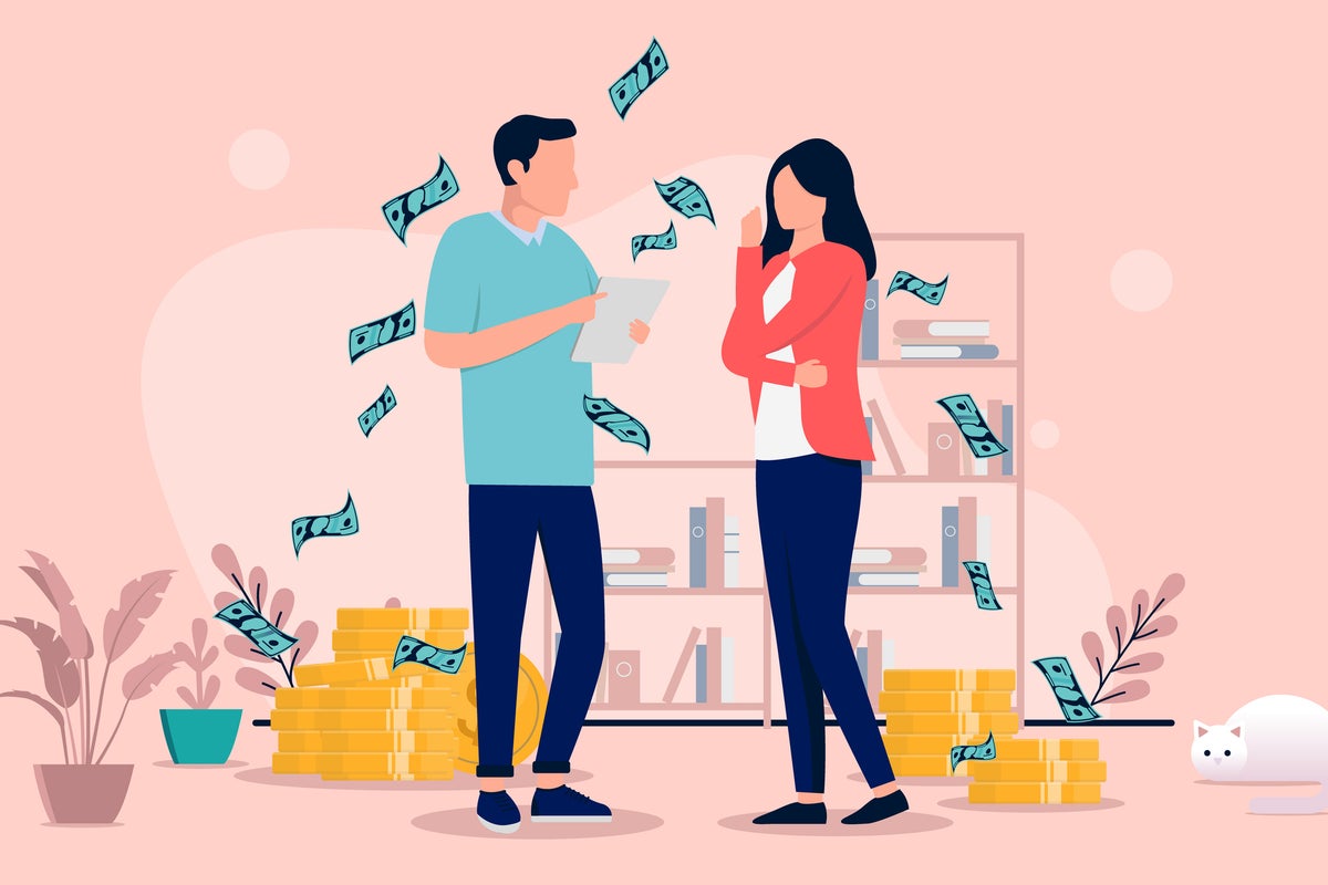 Couple sitting at table surrounded by bills and documents, stressed