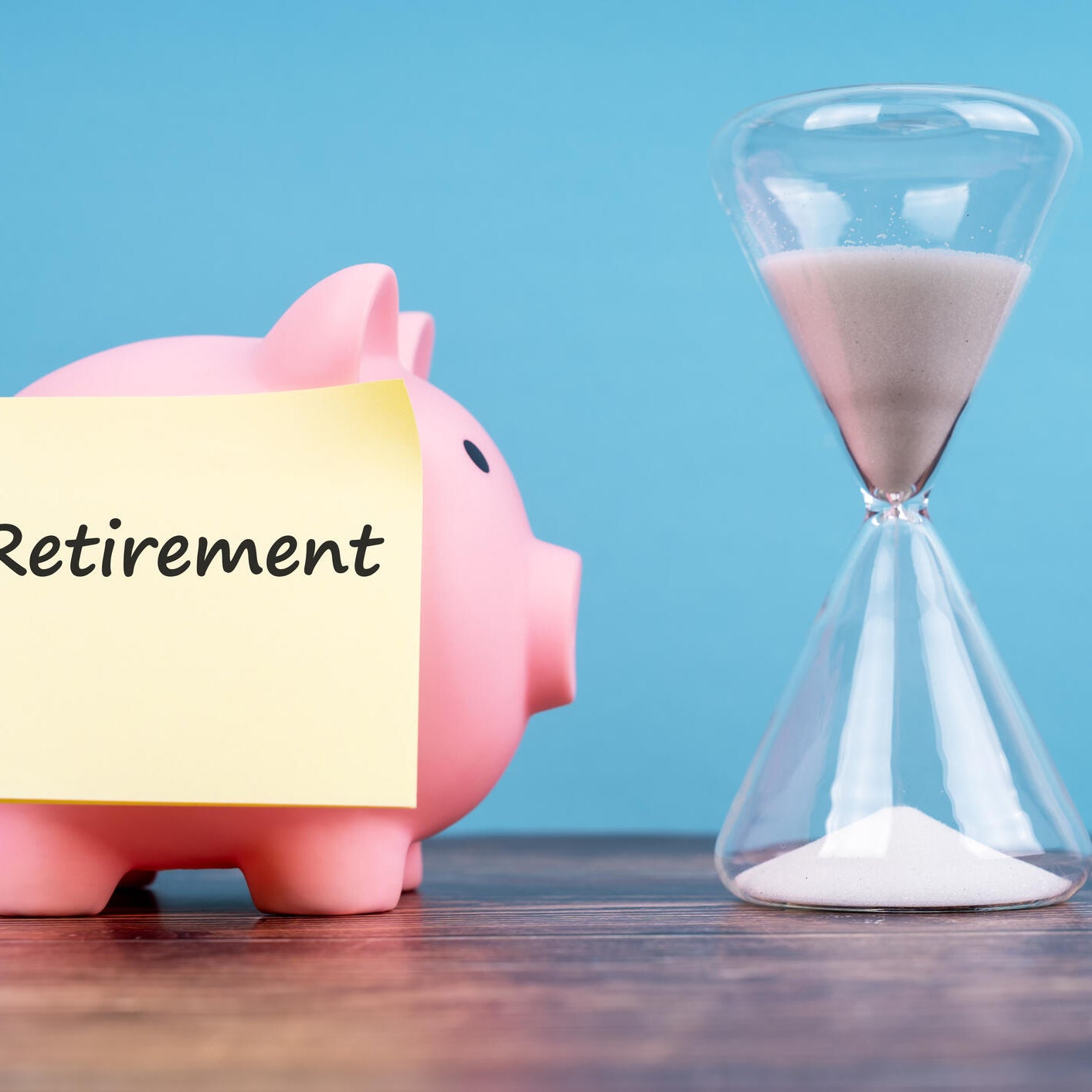 Retirement Text on Adhesive Note, Piggy Bank and Hourglass