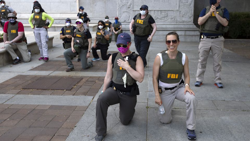 Federal Bureau of Investigation (officers take a knee with demonstrators, as they march on Pennsylvania Ave. on Thursday, June 4, 2020, in Washington, during a protest over the death of George Floyd, an unarmed black man who died after a police officer kneeled on his neck for several minutes.