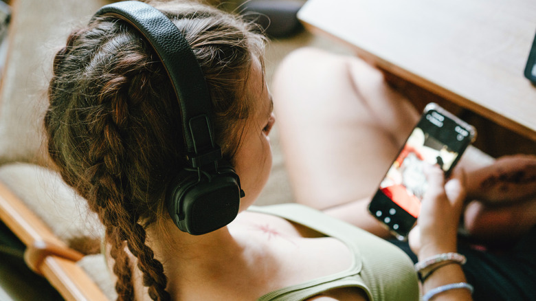 girl listening to music with headphones, smartphone in hand