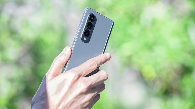 Holding Galaxy Z Fold 4 in outdoor setting