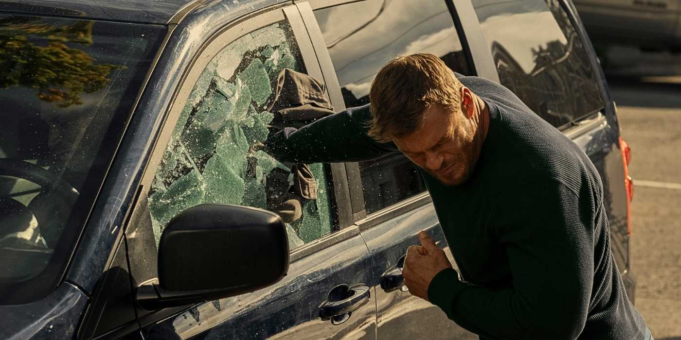 Alan Ritchson as Reacher punching through a car window in Reacher