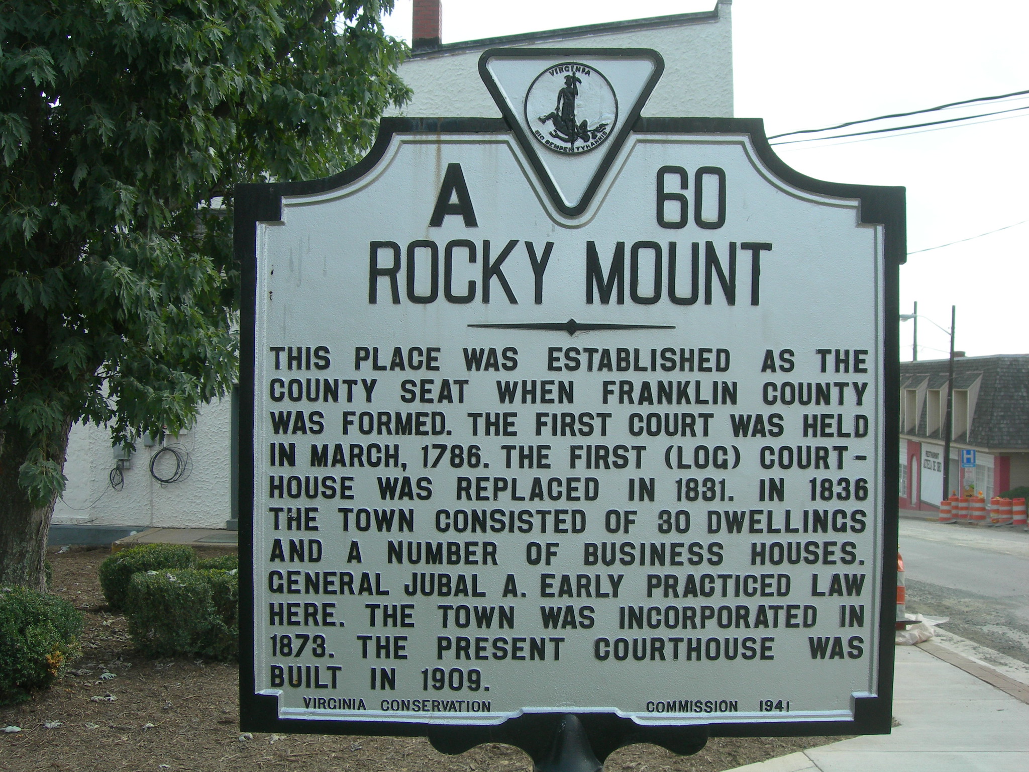 Historic sign for Rocky Mount, VA with a street in the background.