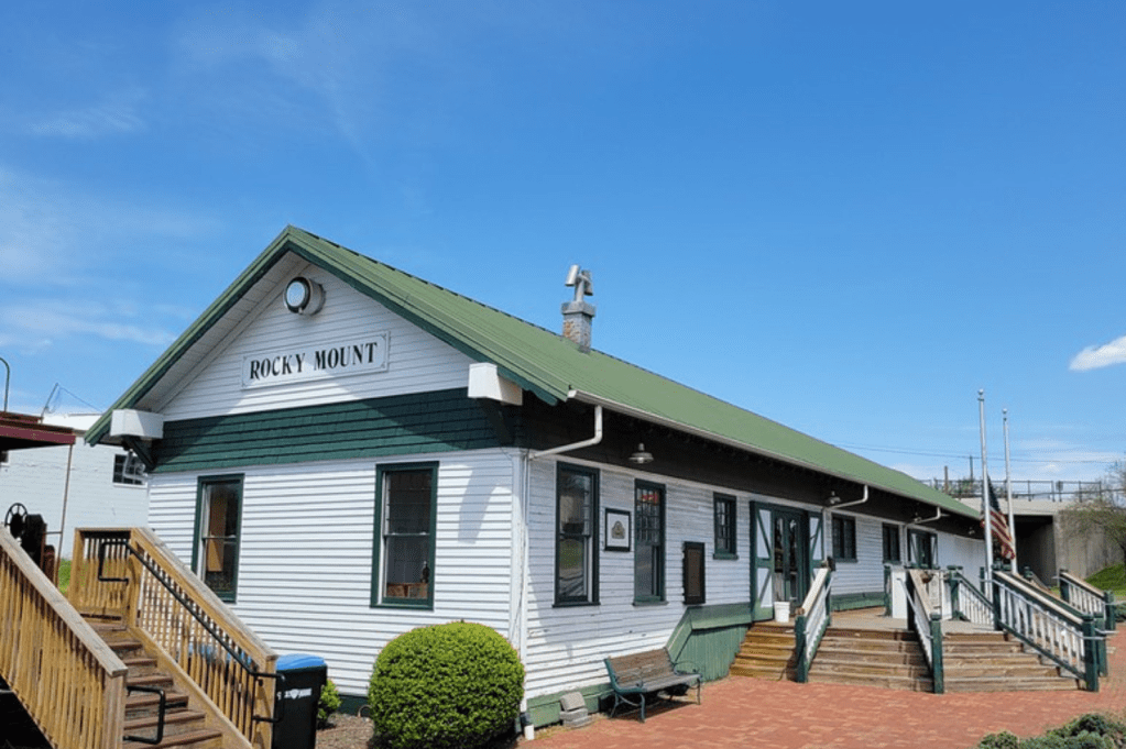 Exterior of old train depot in Rocky Mount, VA. It's a white building with green trimming.