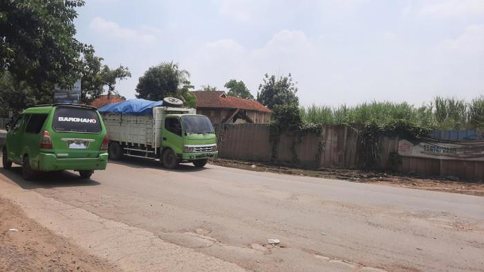 TRUK TAMBANG - Suasana Jalan Raya Mohamad Toha di Parung Panjang, Kabupaten Bogor, pada Senin (22/9/2025). Jalan ini menjadi jalur perlintasan truk tambang dari Kabupaten Bogor ke Legok, Kabupaten Tangerang, Banten. (Warta Kota/Hironimus Rama)