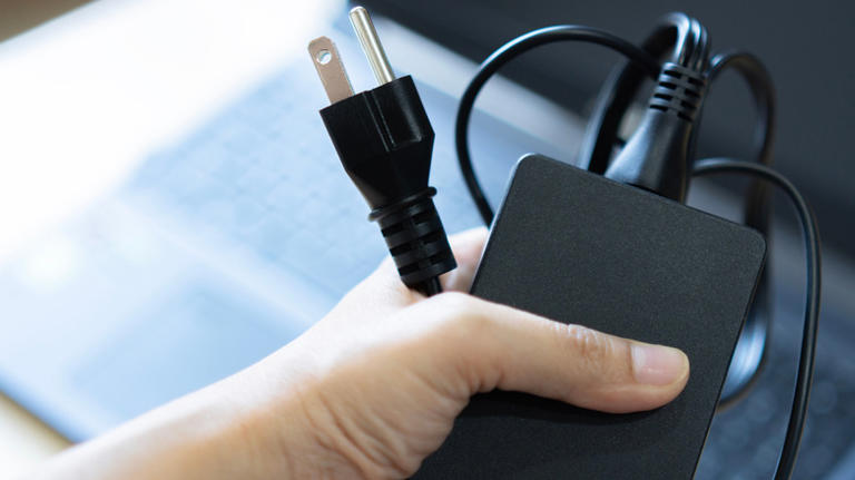 person holding laptop charger