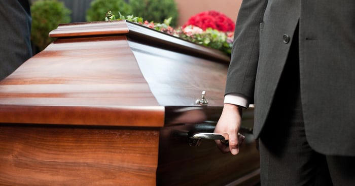 Casket being carried by men in suits.
