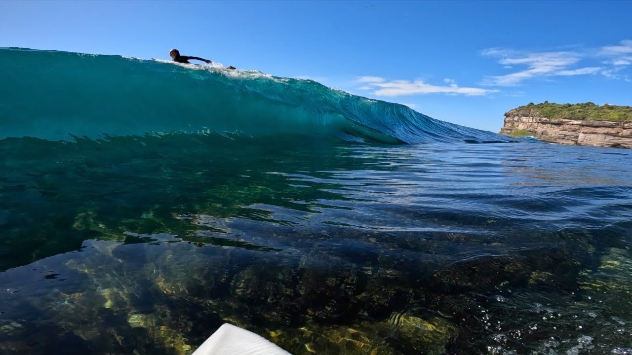Man Surfs a Deadly Slab Above Razor-Sharp Reef