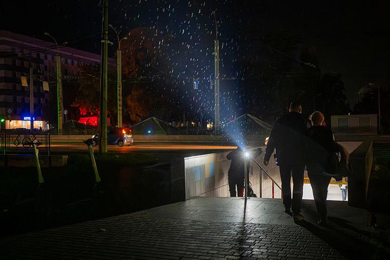 Des personnes sortent d'un passage souterrain pendant une panne d'électricité suite à des frappes russes contre des installations énergétiques à Tchernihiv, le 7 octobre 2025 AP Photo