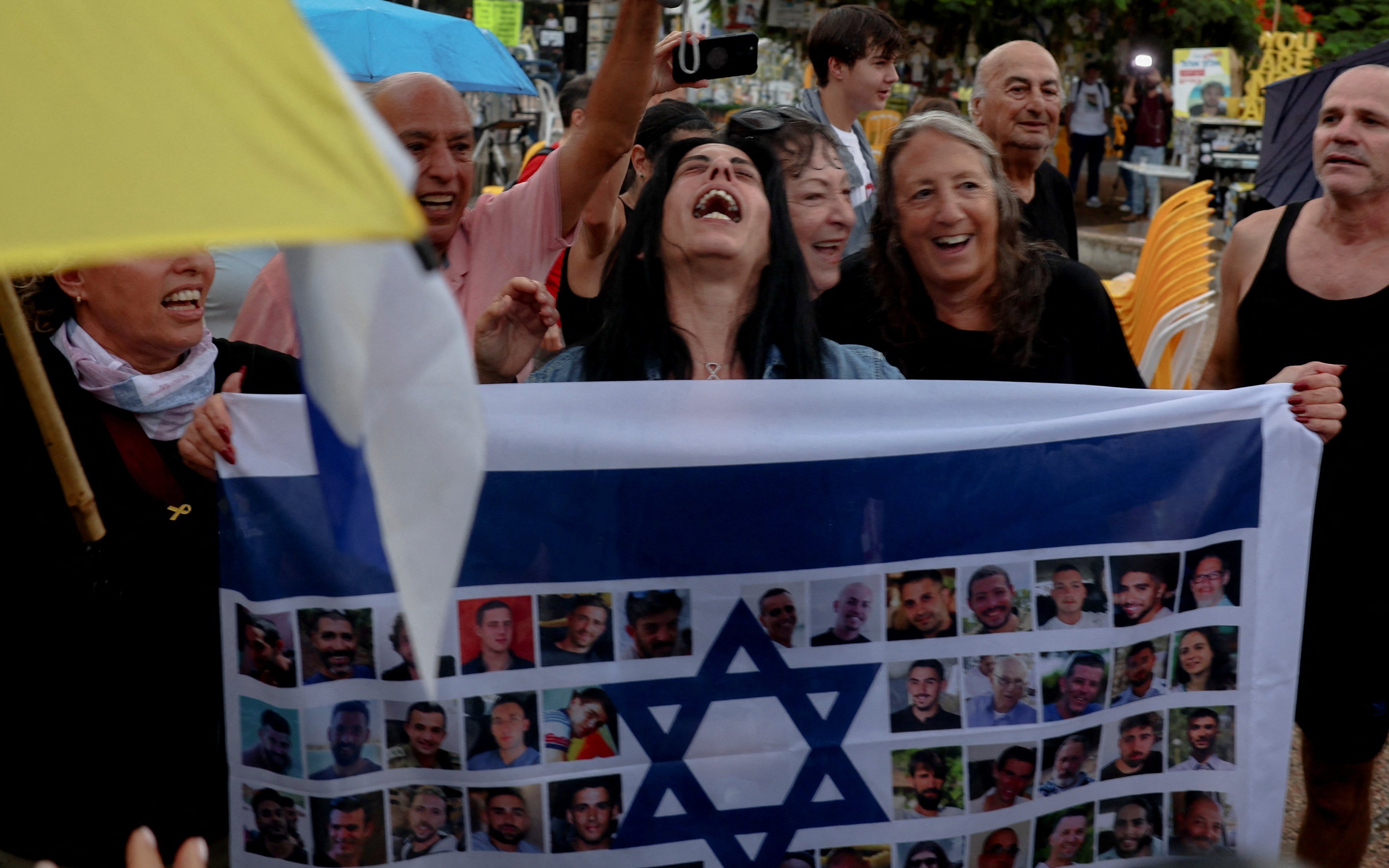 Einav Zangauker, the mother of hostage Matan Zangauker, reacts holding an Israeli flag with photos of hostages, after US President Donald Trump announces that Israel and Hamas agreed on the first phase of a Gaza ceasefire (REUTERS)