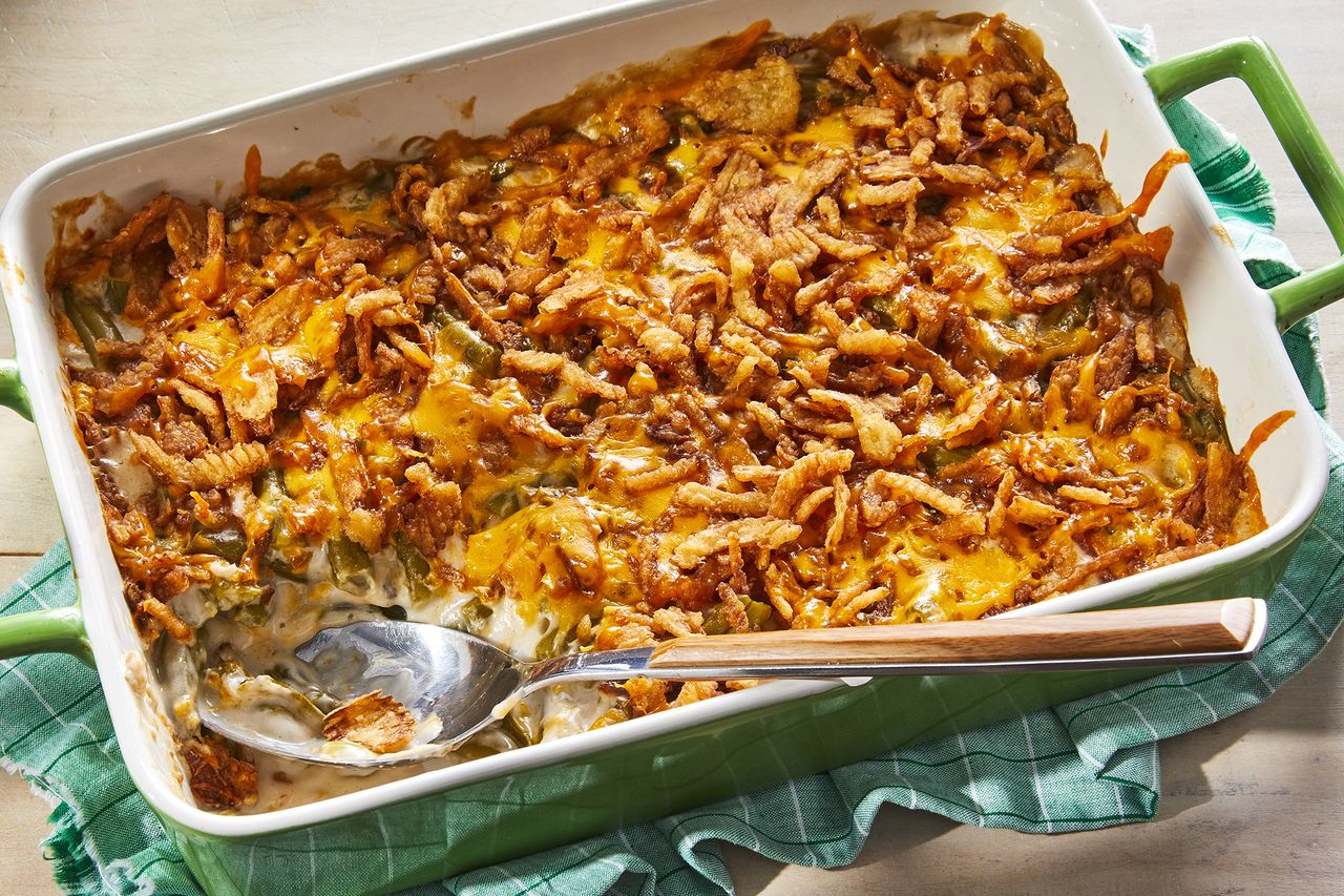 a high angle view looking into a green casserole dish of green bean casserole with a scoop taken out.