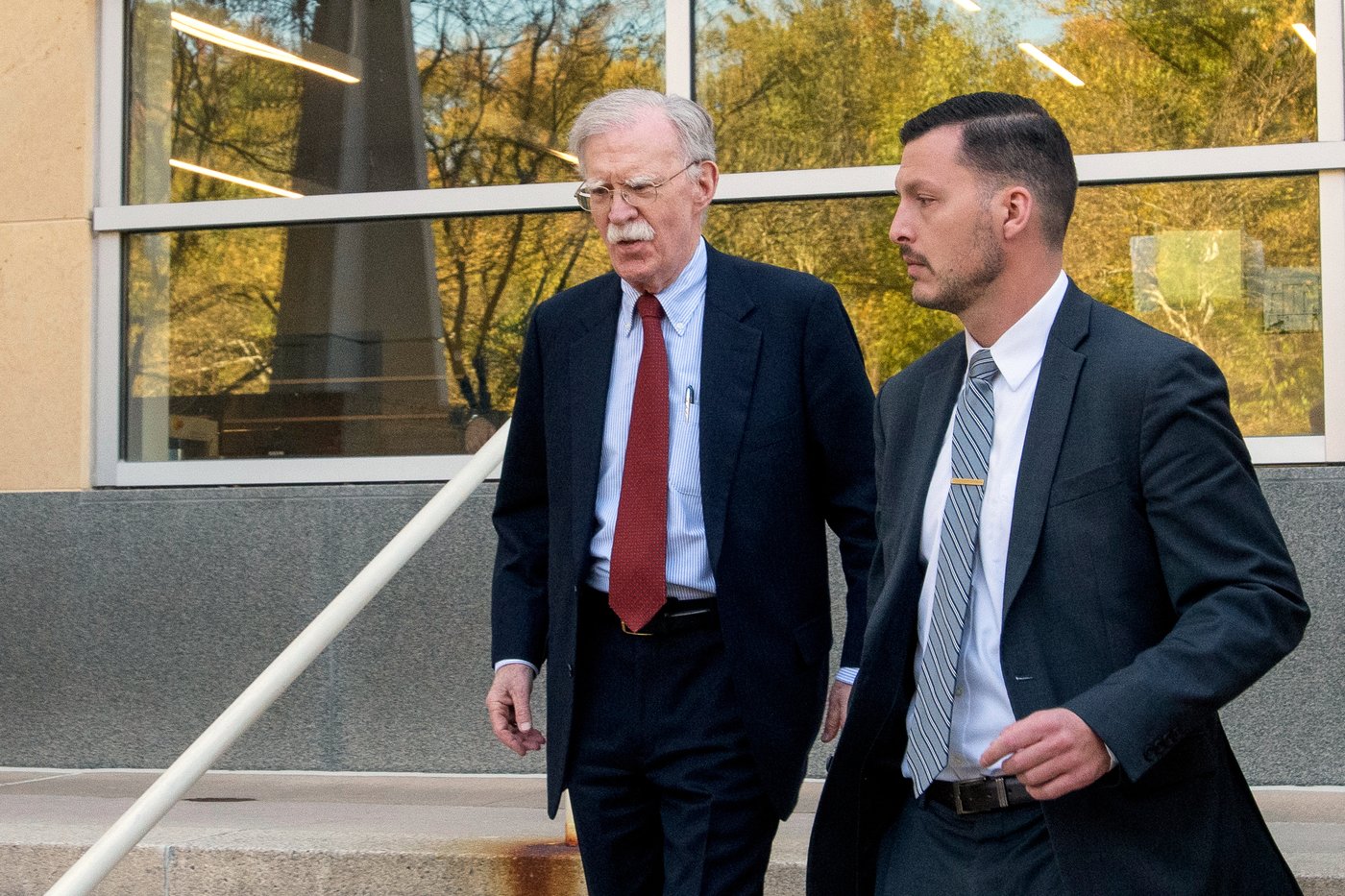 Former Trump administration national security adviser John Bolton, left, departs following his arraignment at the Greenbelt Federal Courthouse in Greenbelt, Md., Friday, Oct. 17, 2025. (AP Photo/Rod Lamkey, Jr.)