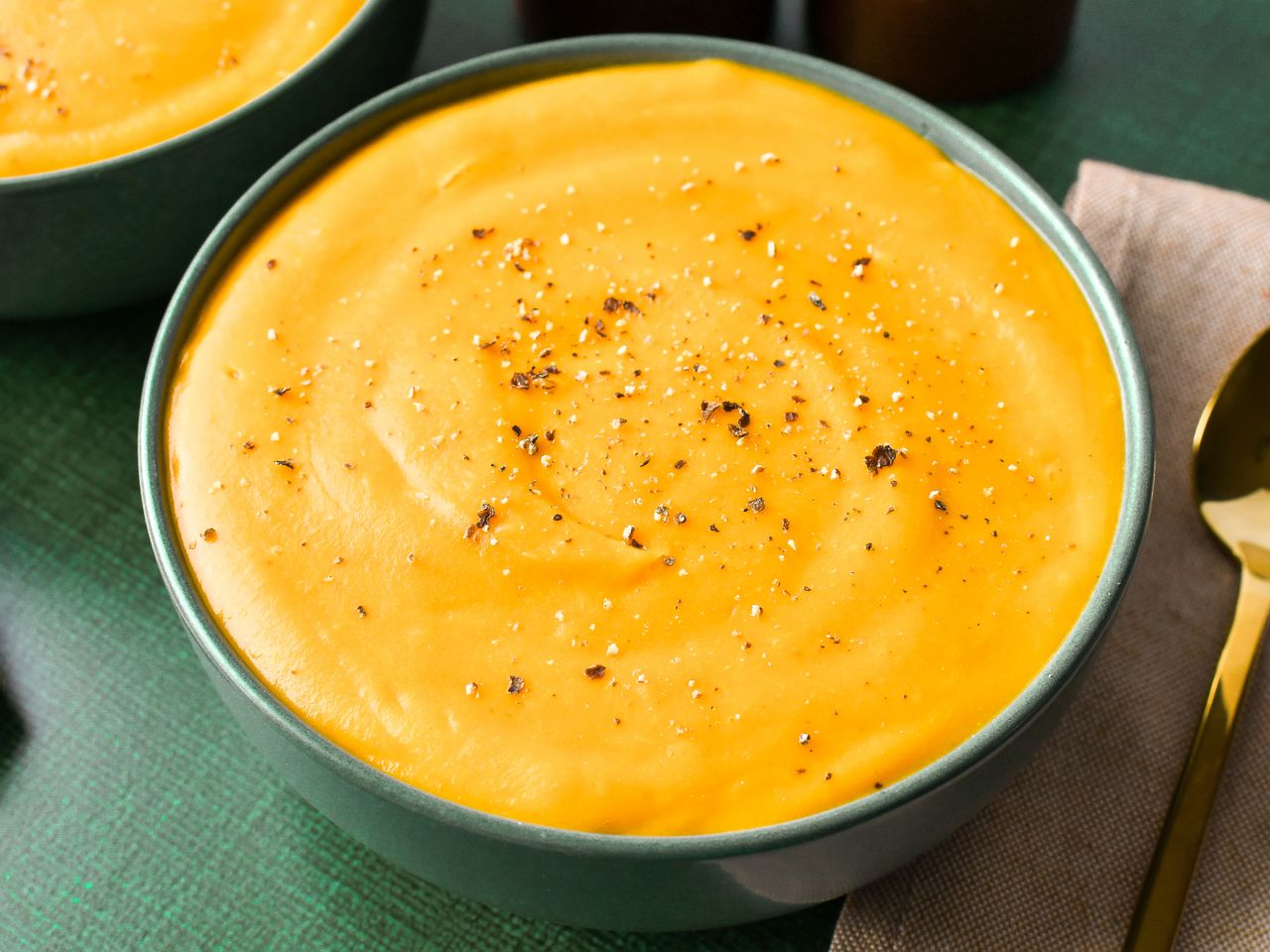 A bowl of creamy butternut squash soup garnished with black pepper