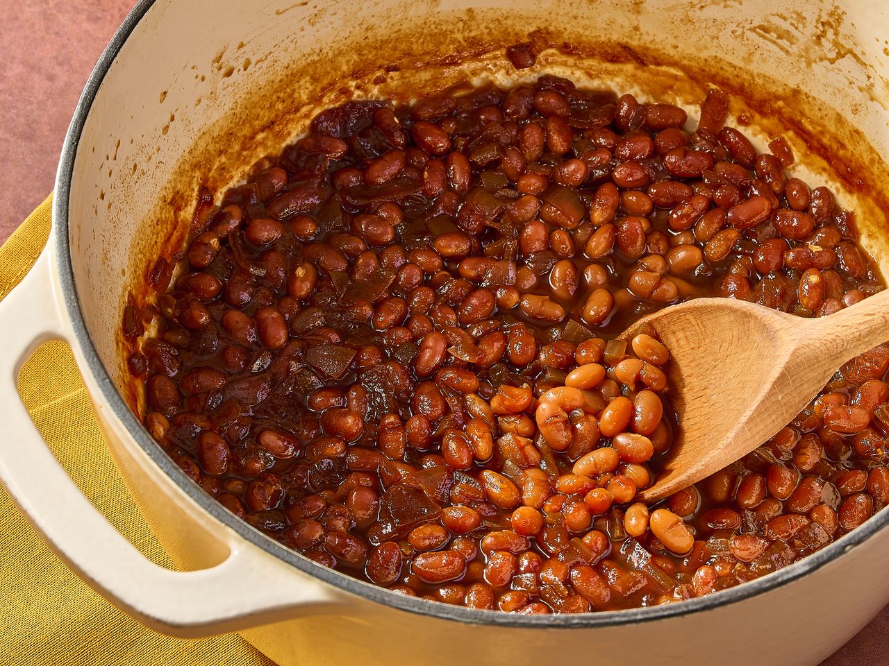 Baked beans in a pot with wooden spoon.