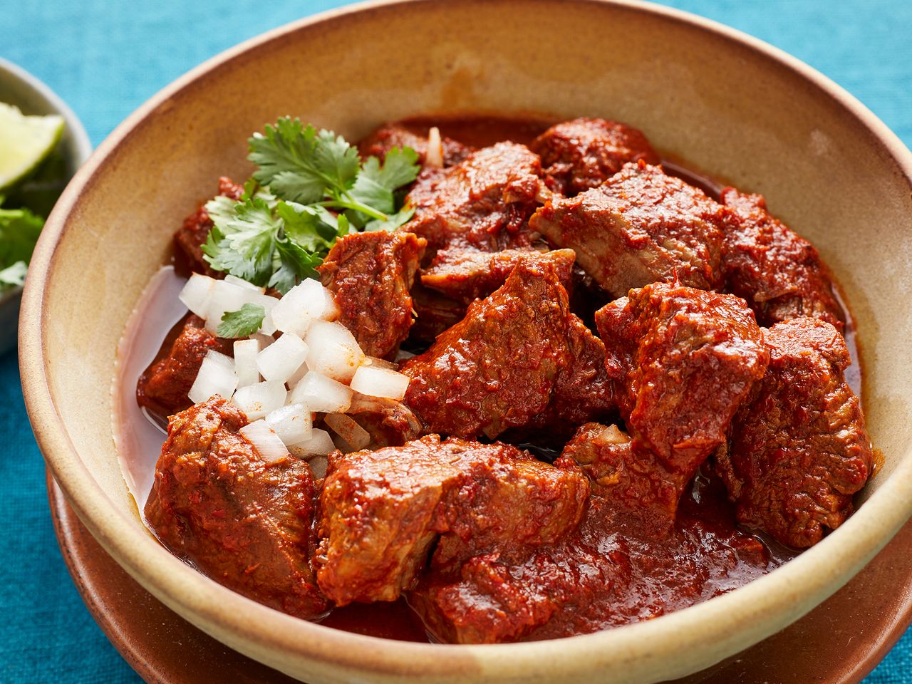 A bowl of birria stew topped with chopped onions and cilantro