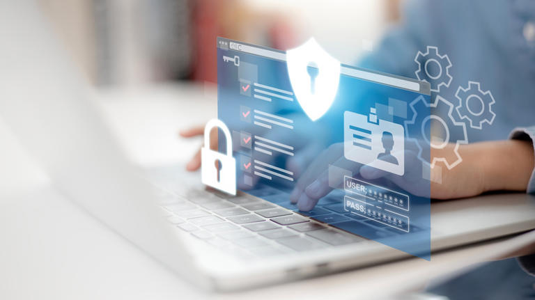 Two hands on the keyboard of a laptop, with a lock, a login screen, and several settings gears digitally imposed over the hands