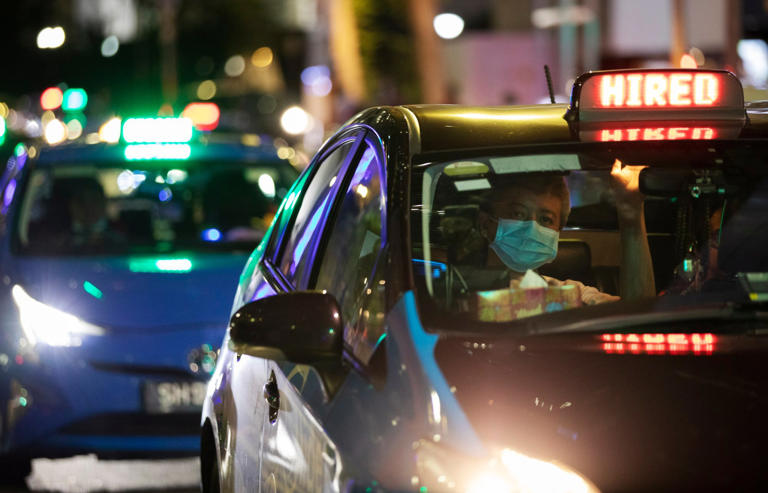 Таксист на светофоре в Сингапуре. Правительства обеих стран стремятся расширить услуги такси в Джохоре. Фото: EPA