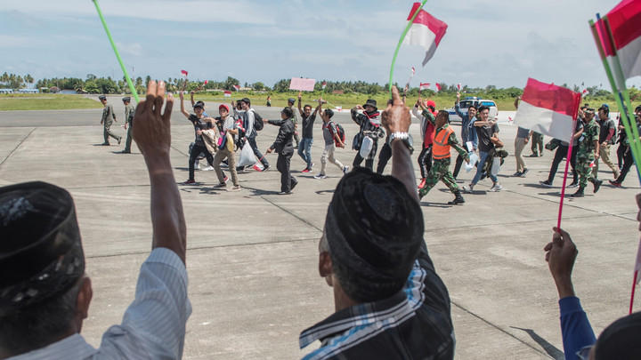Warga Negara Indonesia berjalan menuju pesawat udara di Hanggar Pangkalan Udara TNI AU Raden Sadjad, Ranai, Sabtu (15/2). Foto: ANTARA FOTO/Muhammad Adimaja