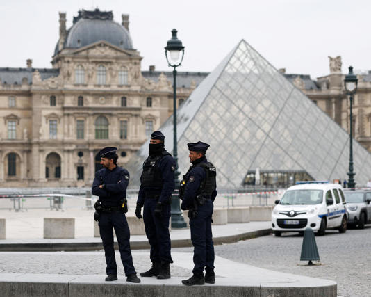 Police stand near the pyramid of the Louvre museum on Sunday. Photograph: Gonzalo Fuentes/Reuters