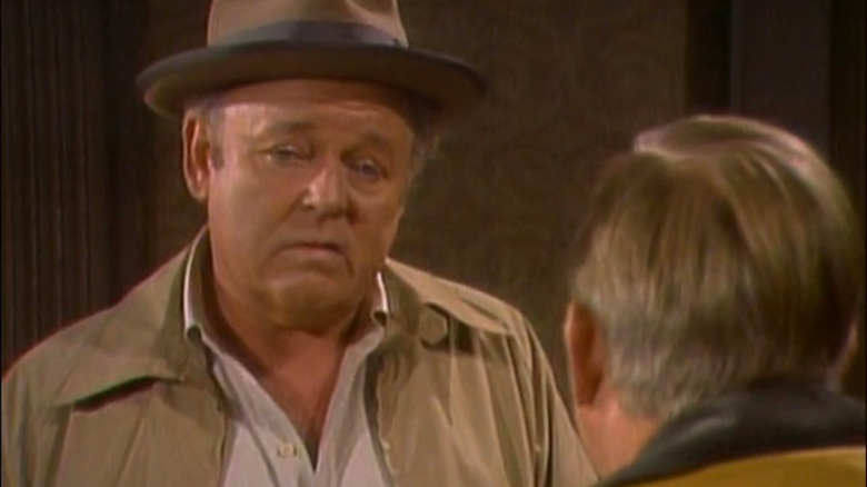 Archie grimacing behind the bar in Archie Bunker's Place