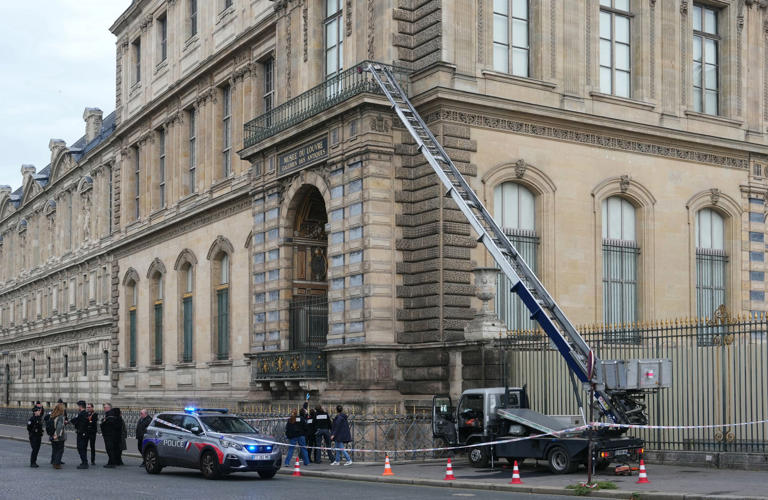 French police officers stand next to a furniture elevator used by robbers to enter the Louvre Museum (AFP via Getty Images)