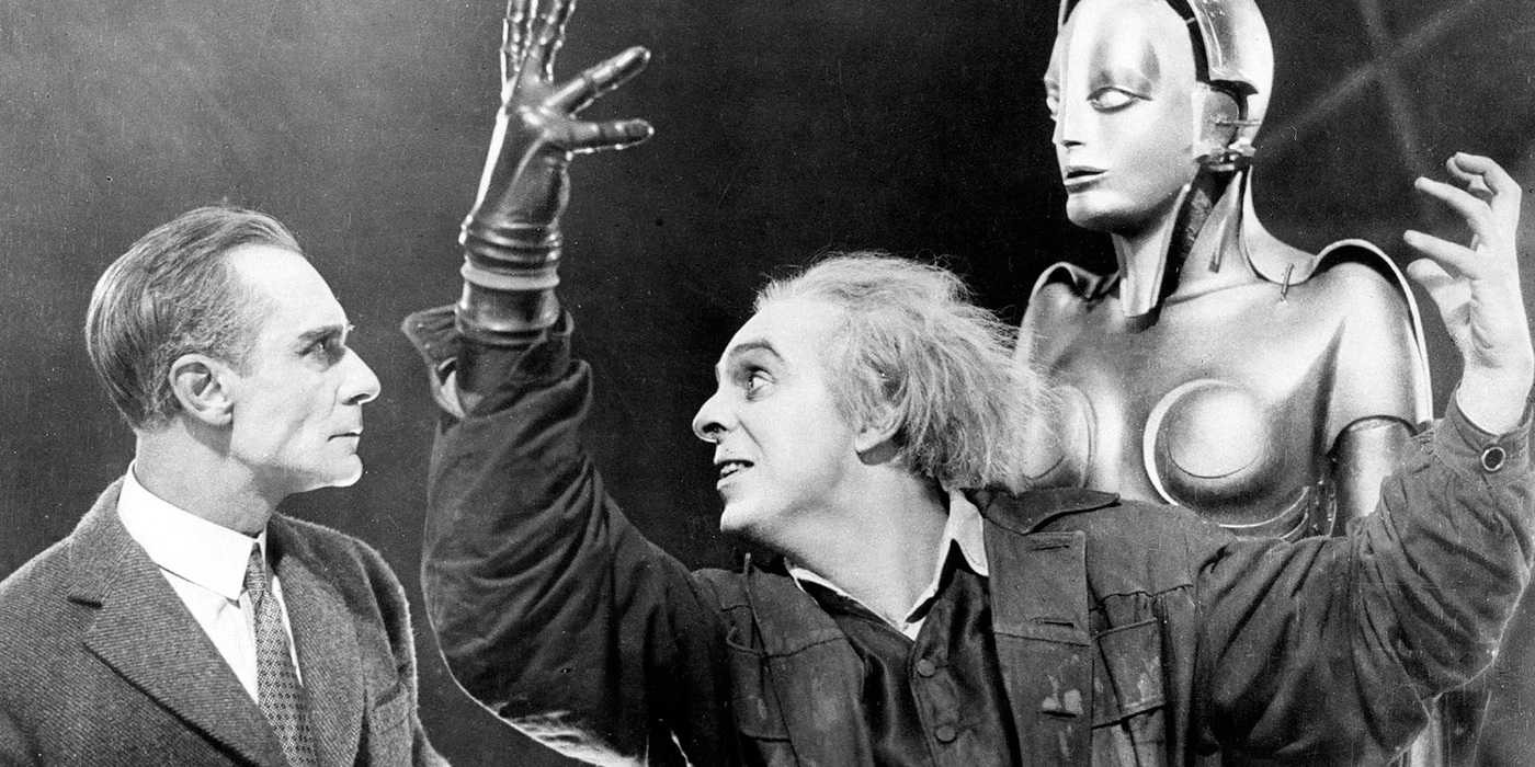 A scientist gestures broadly in front of his robot as another man looks on in Metropolis