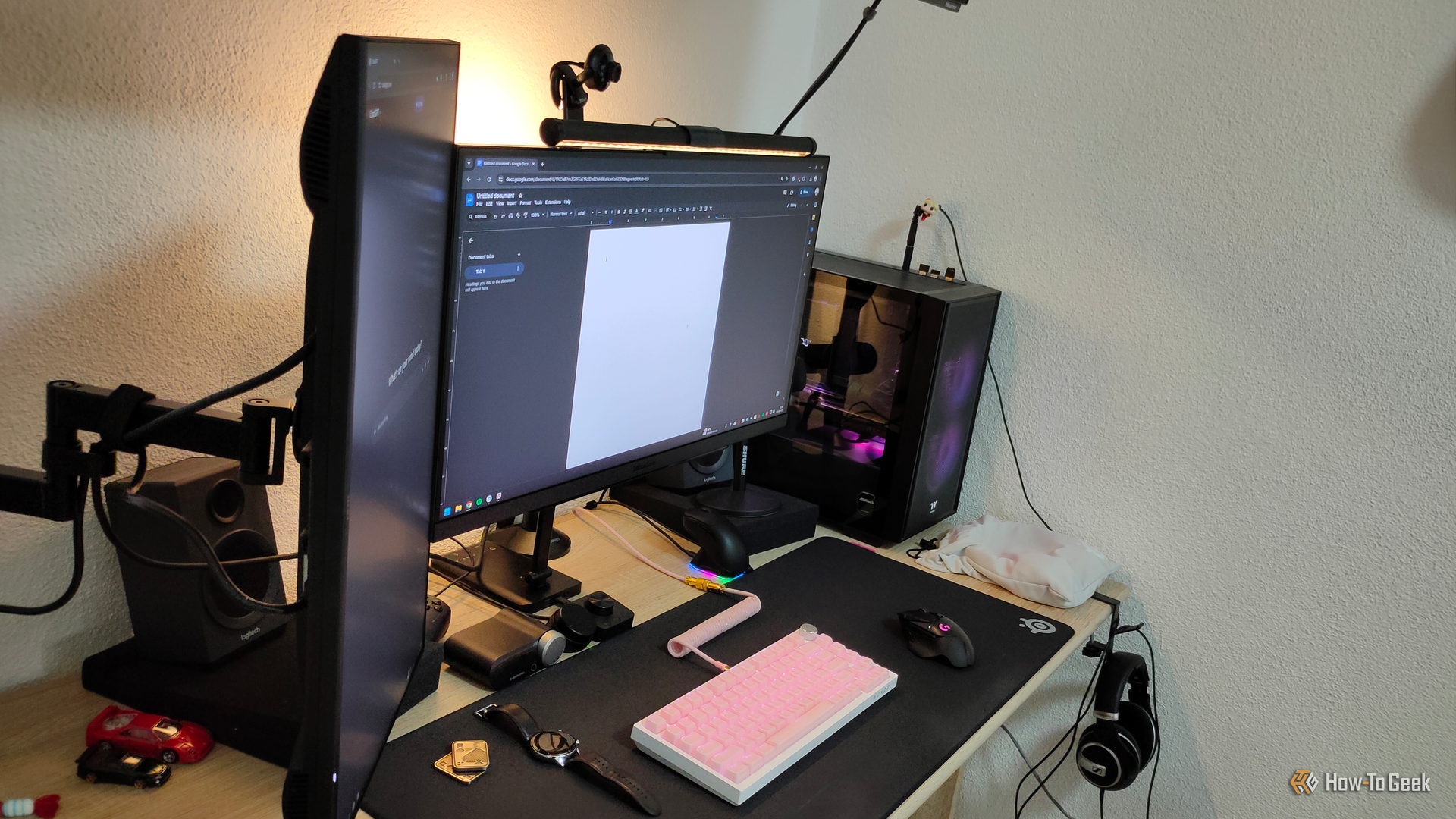 A vertical monitor with a monitor arm and a main monitor on a desktop PC.