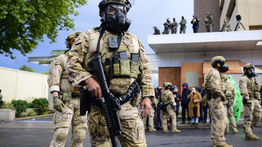 Federal agents clash with anti-ICE protesters at the US Immigration and Customs Enforcement building on October 12 in Portland, Oregon. - Mathieu Lewis-Rolland/Getty Images