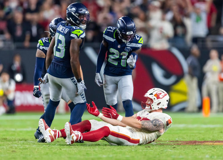 Sep 25, 2025; Glendale, Arizona, USA; Seattle Seahawks linebacker Ernest Jones IV (13) and cornerback Devon Witherspoon (21) react after breaking up a pass to Arizona Cardinals tight end Trey McBride (85) at State Farm Stadium. Mandatory Credit: Mark J. Rebilas-Imagn Images