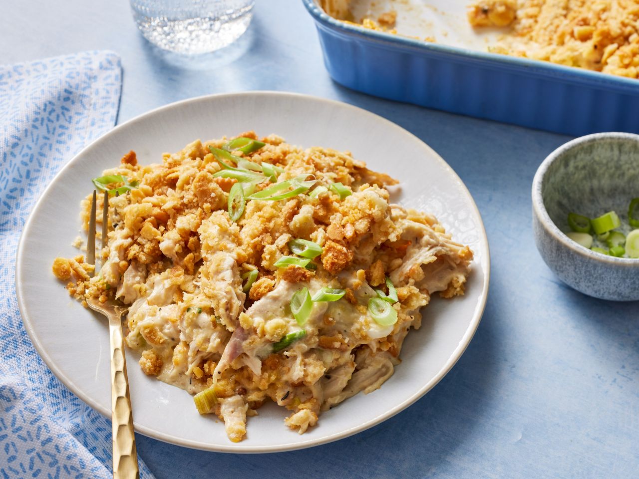 Ritz Cracker Chicken Casserole garnished with green onions on a plate with a fork