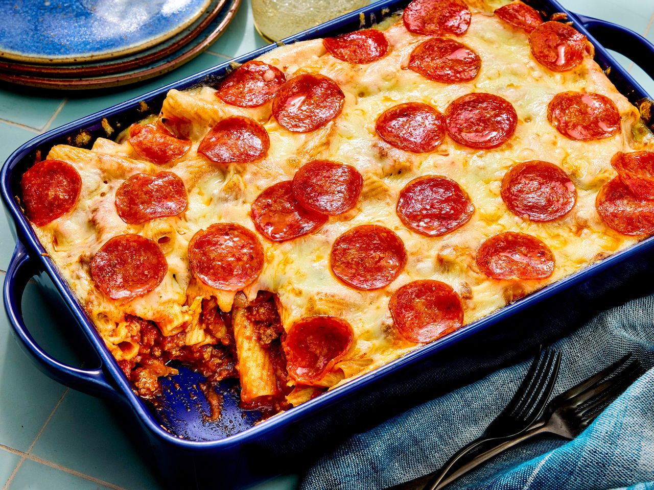 Baked pepperoni pasta casserole with melted cheese in dish.