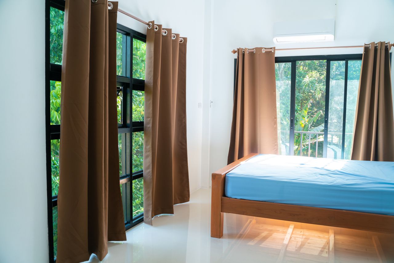 Bedroom interior with curtains a window a bed and natural light coming through