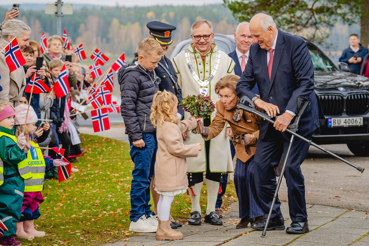 Kong Harald og dronning Sonja før blomster av Ingrid Cornelia Sydnes og Emil Oliver Vestby under besøket til Aremark kommune i Østfold fylke. Etter dette besøket har kongeparet besøkt alle kommunene i Østfold fylke. Foto: Stian Lysberg Solum / NTB