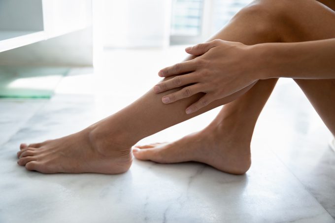 Female touches smooth silky legacies enjoy skin after epilation procedure