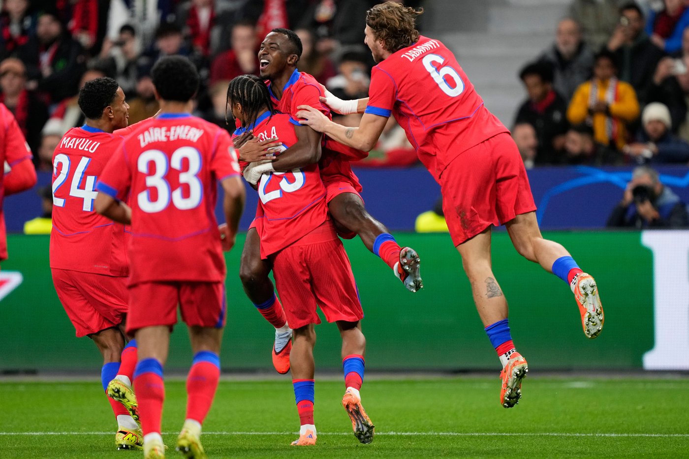 PSG's Willian Pacho celebrates with his teammates after scoring his side's first goal during a Champions League opening phase soccer match between Bayer Leverkusen and Paris Saint-Germain in Leverkusen, Germany, Tuesday, Oct. 21, 2025. (AP Photo/Martin Meissner)