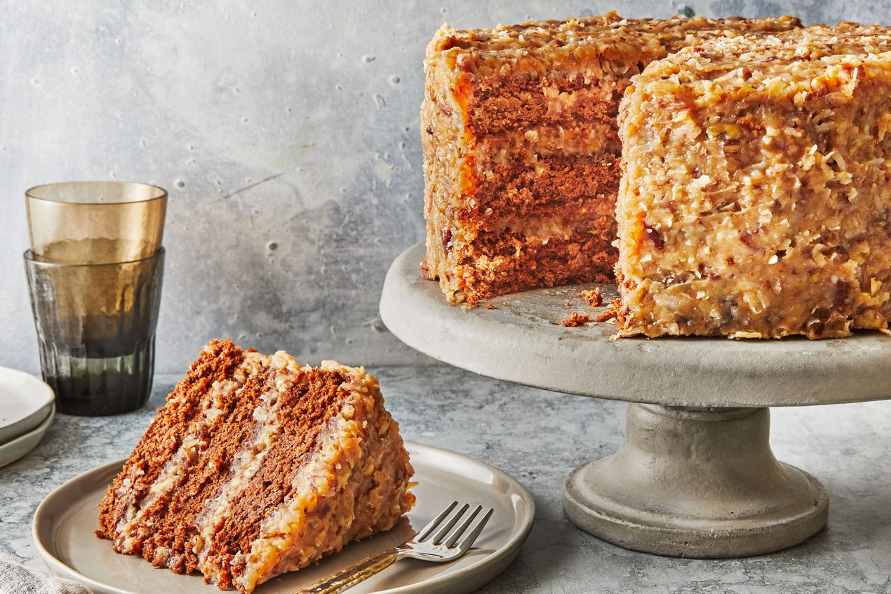 Southern Living German Chocolate Cake on a cake plate with a slice cut out to serve