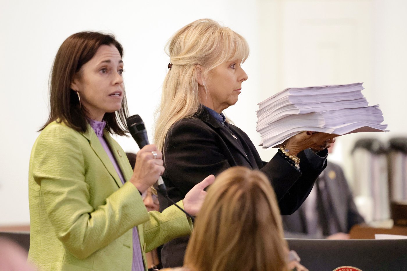 Rep. Beth Helfrich, D-Mecklenberg, left, refers to a stack of public comments held by Rep. Julia Greenfield, D-Mecklenberg, right, during debate on a redistricting bill at the Legislative Building, Wednesday, Oct. 22, 2025, in Raleigh, N.C. (AP Photo/Chris Seward)
