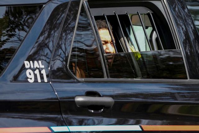 Derrick Groves sits in a police vehicle after being taken into custody on Oct. 8, 2025.