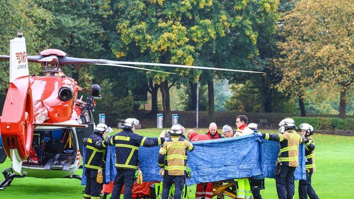 Einsatzkräfte stehen neben einem Rettungshubschrauber. Die neu gewählte Bürgermeisterin von Herdecke, Iris Stalzer (SPD), ist lebensgefährlich verletzt worden. (Quelle: Alex Talash/dpa)
