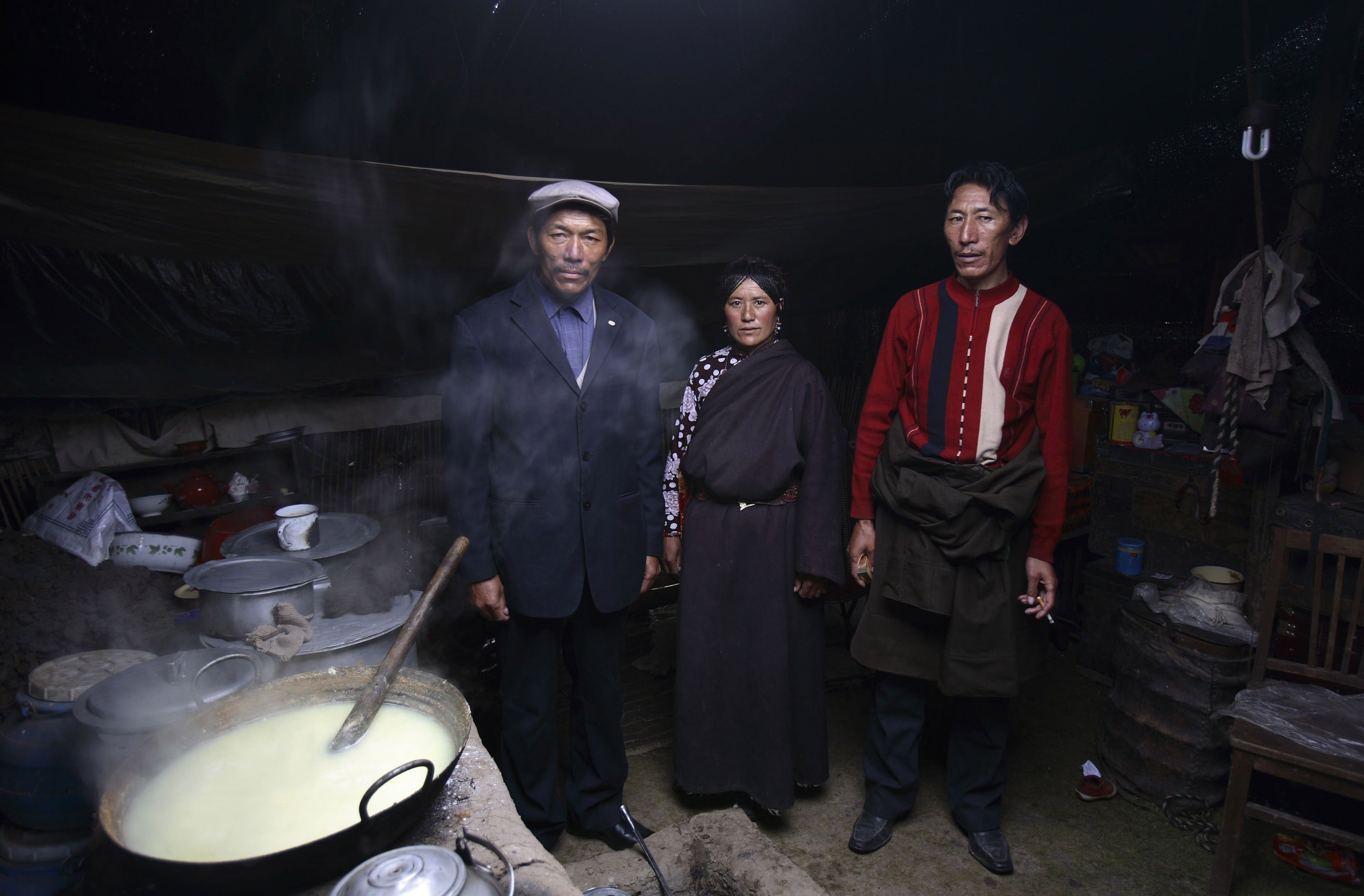 Tibetan man Gama Sangding poses for a photo with his elder brother La Wen and their common wife Cai Zhuo, in their tent at the Burong Village on 18 July 2007 (Getty Images)