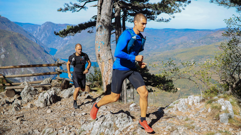 Two men running on a high mountain trail